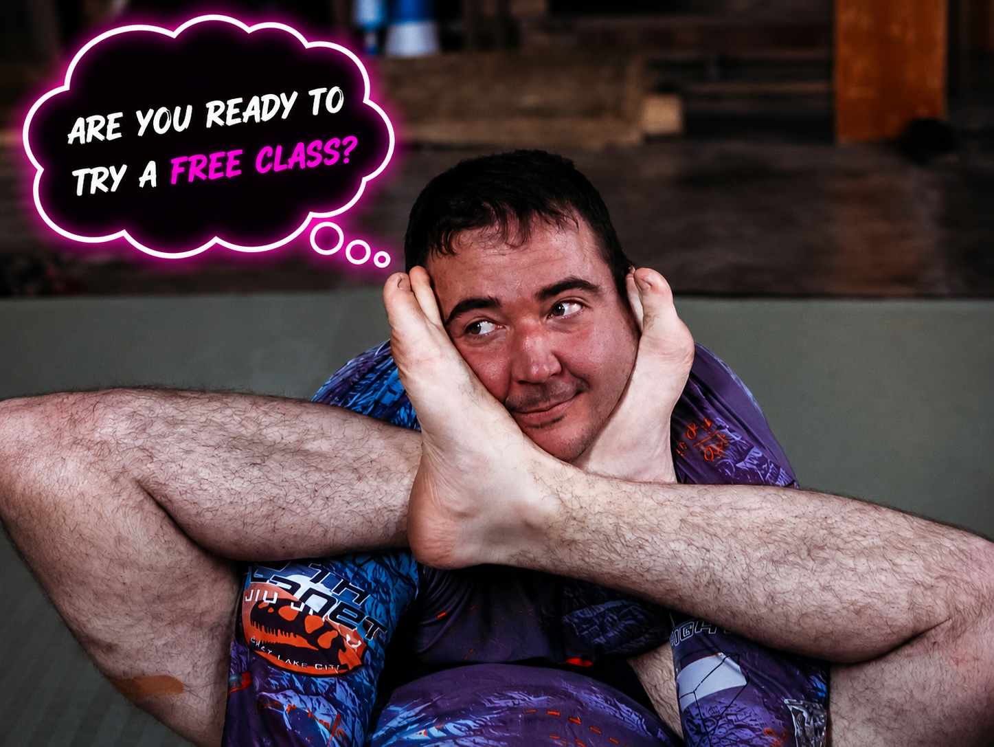 A grappler grinning while folded into a tight pin, with a glowing neon speech bubble asking 'Are you ready to try a free class?'